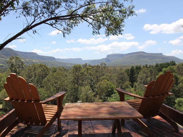 Timber chairs and table on the lookout deck facing the escarpment